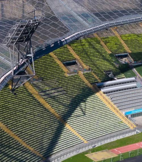 Zahlreiche Sitzreihen und das Zeltdach sind im Olympiapark im Olympiastadion zu sehen. München bewirbt sich um die Austragung der Olympischen und Paralympischen Sommerspiele im Jahr 2036, 2040 oder 2044.